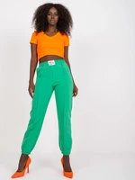 Dark green women's trousers made of fabric with crease